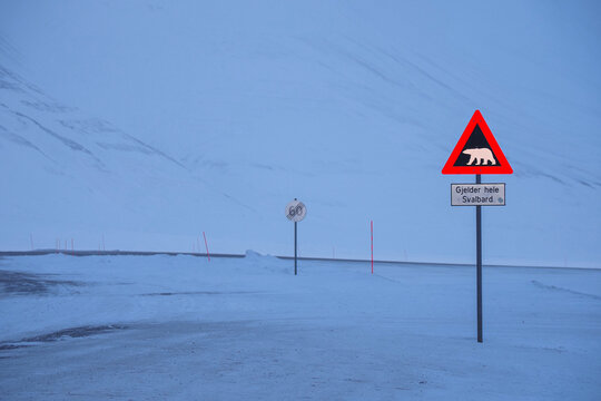 olar bear warning sign on a deserted snowy road in the Arctic, emphasizing the remote and harsh environment. Svalbard, Longyearbyen