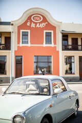 vintage car in front of orange hotel