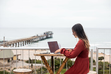 woman sitting on the terrace with a laptop for remote work