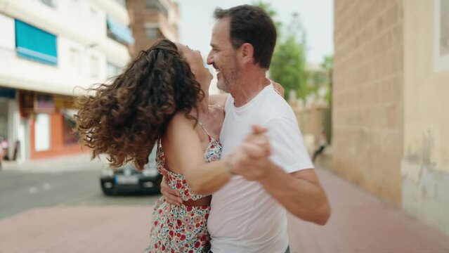 Man and woman couple smiling confident dancing at street