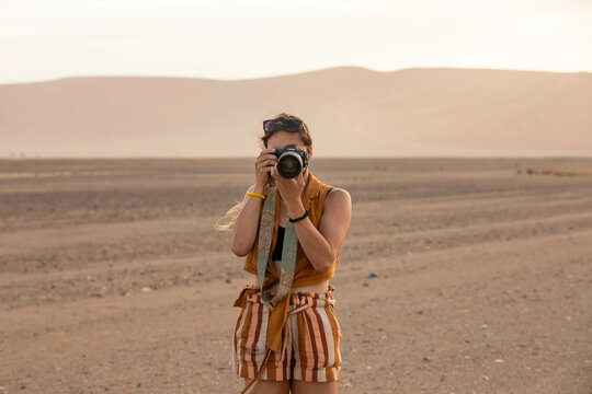 female photographer taking a photo in the desert