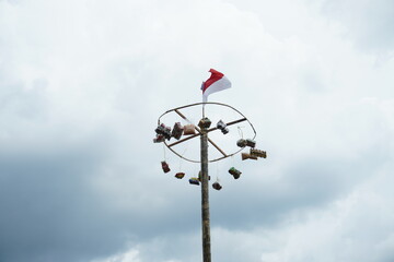 areca climbing competition when celebrating Indonesia's independence day by hanging gifts on a pole from a areca tree
