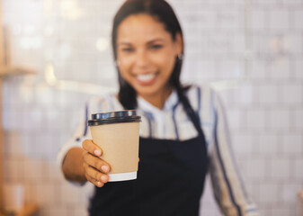 Coffee shop, closeup and barista holding cup and giving it to the customer at cafe. Female restaurant service worker in beverage business. Small business, management and food worker serving client.