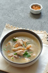 a bowl of chicken soup in grey background