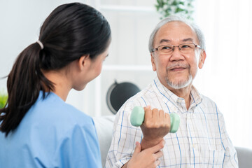 Contented senior patient doing physical therapy with the help of his caregiver. Senior physical therapy, physiotherapy treatment, nursing home for the elderly