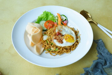 a plate of fried noodles served with vegetables 
