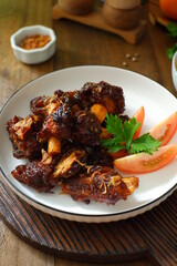a plate of grilled beef ribs served with vegetables 