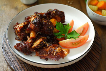 a plate of grilled beef ribs served with vegetables 