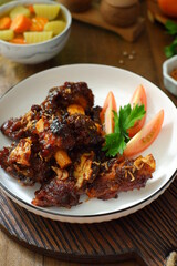 a plate of grilled beef ribs served with vegetables 