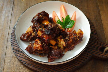 a plate of grilled beef ribs served with vegetables 