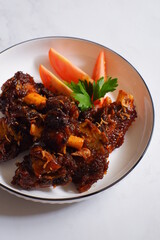 a plate of grilled beef ribs served with vegetables 