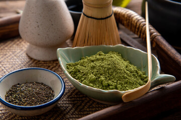 Matcha fine powdered green tea set . Japanese organic matcha green tea powder in bowl with wire whisk on wooden table background.