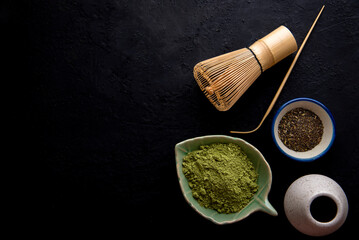 Matcha fine powdered green tea set . Japanese organic matcha green tea powder in bowl with wire whisk on wooden table background.
