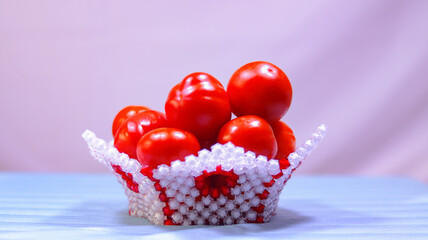 Ripe tomatoes in a basket. Red and white basket.. Fresh tomatoes in a basket