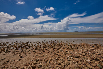 The blue sky on the beach untidy and deserted with sand stone