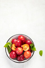 Plate of fresh ripe plums on table.