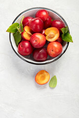 Plate of fresh ripe plums on table.