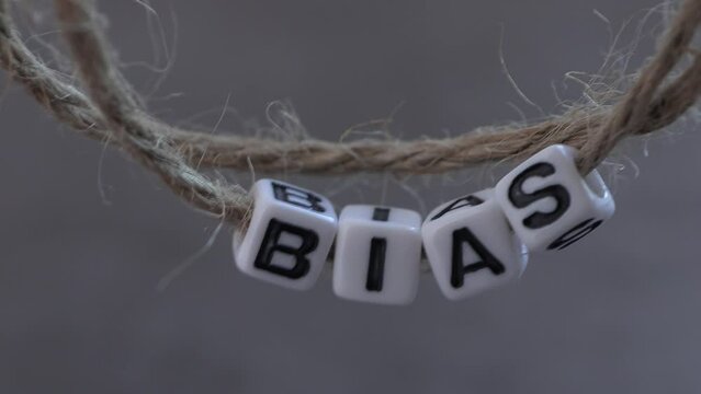 BIAS text on white cubes with string. 
