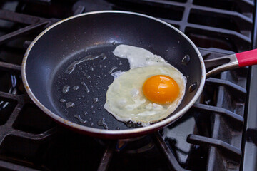 chica joven prepara hermosos huevos en la sartén para el desayuno.