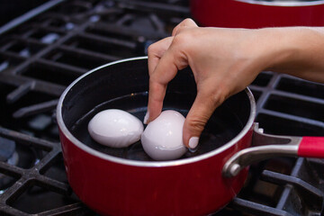 chica joven prepara hermosos huevos en sartén para el desayuno.