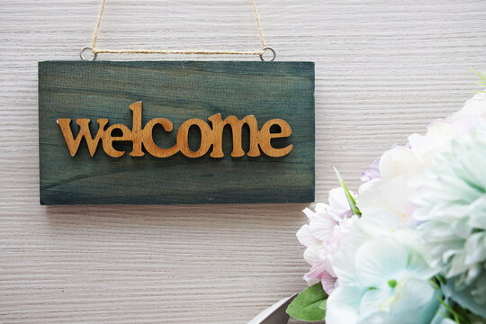Welcome Sign and flower bouquet decoration on wooden background