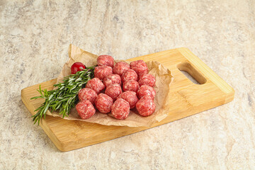 Raw uncooked beef meatballs served rosemary