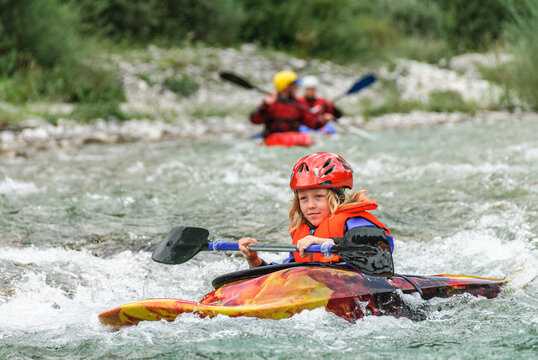 Junge Wassersportlerin steuert ihr Kajak durch das smaragdgr&uuml;ne Wasser der  Soca