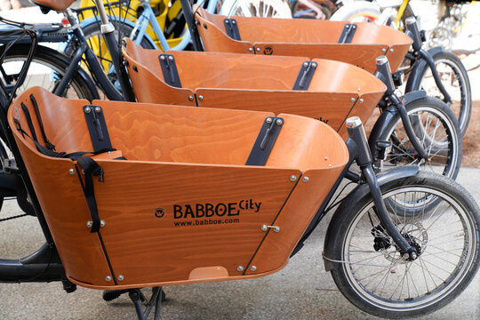 Babboe city logo sign and text brand on Curve Cargobike Several Dog cargo bikes in front of a bike shop