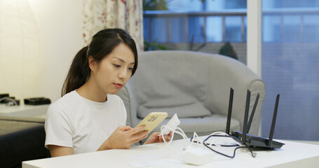 Woman study to connect the cable with router