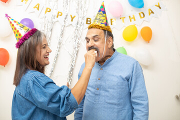 Happy Indian asian old couple celebrate birthday. Eat cake, holidays and retired people concept.