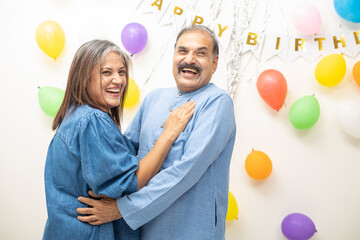 Happy Indian asian old couple celebrate birthday. elderly retired people doing party dancing together.