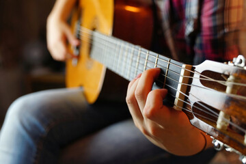 Fototapeta premium The girl teenager plays the guitar.