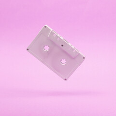 Levitating white audio cassette on pink background. 3D photo. Minimalistic still life. Creative layout. Concept art