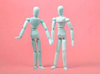 Loving couple of puppets hold hands on pink background. Love, romantic concept