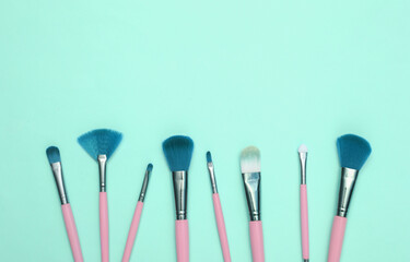 Makeup brushes on blue background. Beauty layout. Flat lay. Minimalism