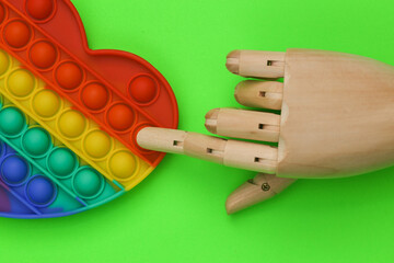 Hand touch pop it antistress toy on green background