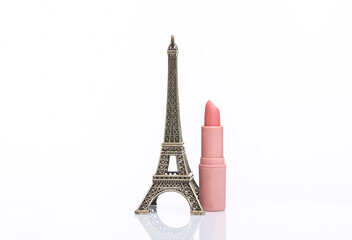Eiffel tower miniature with lipstick tube isolated on white background