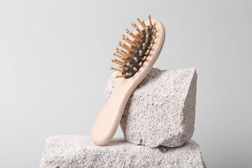 Wooden eco hair brush stone showcase, gray background. Natural eco concept. Minimal still life. Abstract composition