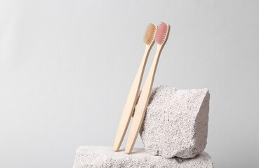 Natural eco concept. Bamboo toothbrushes with stones on a gray background. Dental care. Creative minimal still life. Product photo