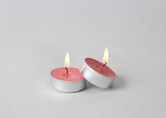 Flaming scented tea candles on gray background
