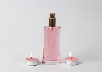 Obraz na płótnie Canvas Aromatherapy. Perfume bottle with aromatic candles on a gray background
