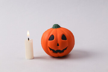 Halloween pumpkin with candle on gray background