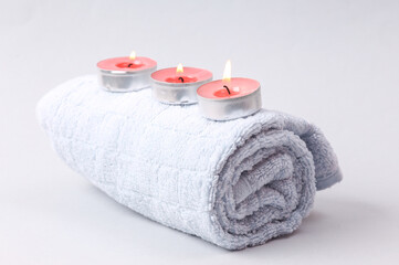 Obraz na płótnie Canvas Aromatherapy, spa salon. Scented candles with towel on gray background