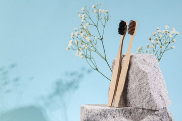 Natural eco concept. Bamboo toothbrushes with stones on blue background. Dental care. Creative...
