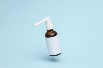 Throat spray flying in antigravity on blue background with shadow. Levitation object in the air. Medicine croncept. Creative minimal layout