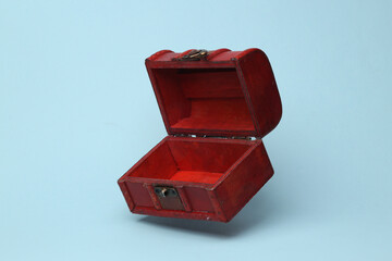 Red open pirate chest flying in antigravity on blue background with shadow. Levitation object in the air. Creative minimal layout