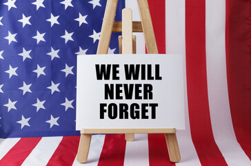 The flag of the United States has a sign that says - We will never forget