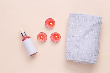 Spa salon, beauty concept. Serum bottle with aroma candles and a towel on a beige background