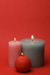 Flaming wax candles on a red background