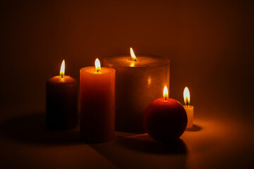 Fototapeta na wymiar Flaming candles on a dark black background